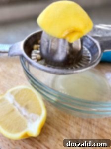 Tequila Citrus Surprise 3 Fresh lemon being juiced for the cocktail.