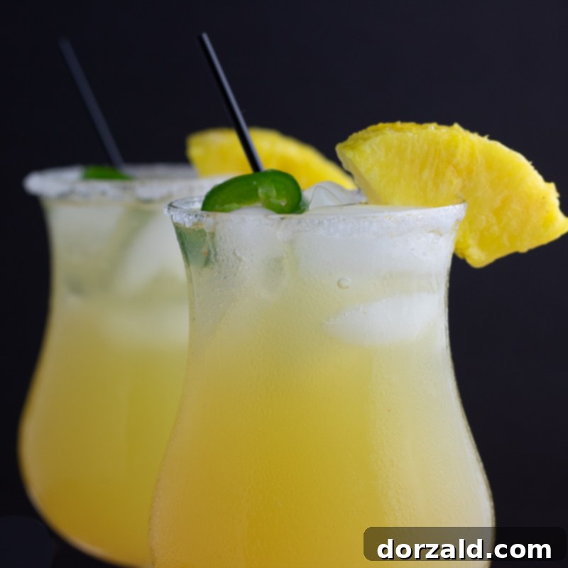 Fiery Sweet Siren 3 two glasses of sweet hot mama cocktail closeup with pineapple and jalapeño