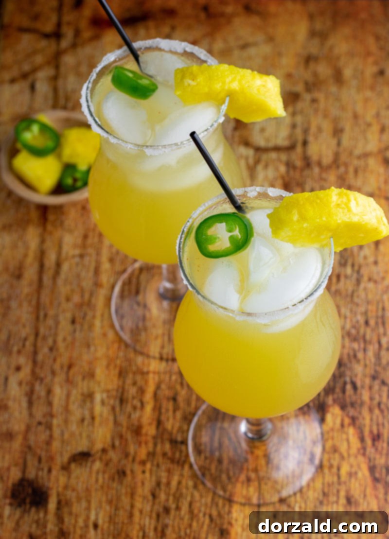 Fiery Sweet Siren 4 overhead of two cocktails with pineapple ice and jalapeño - recipe sweet hot mama