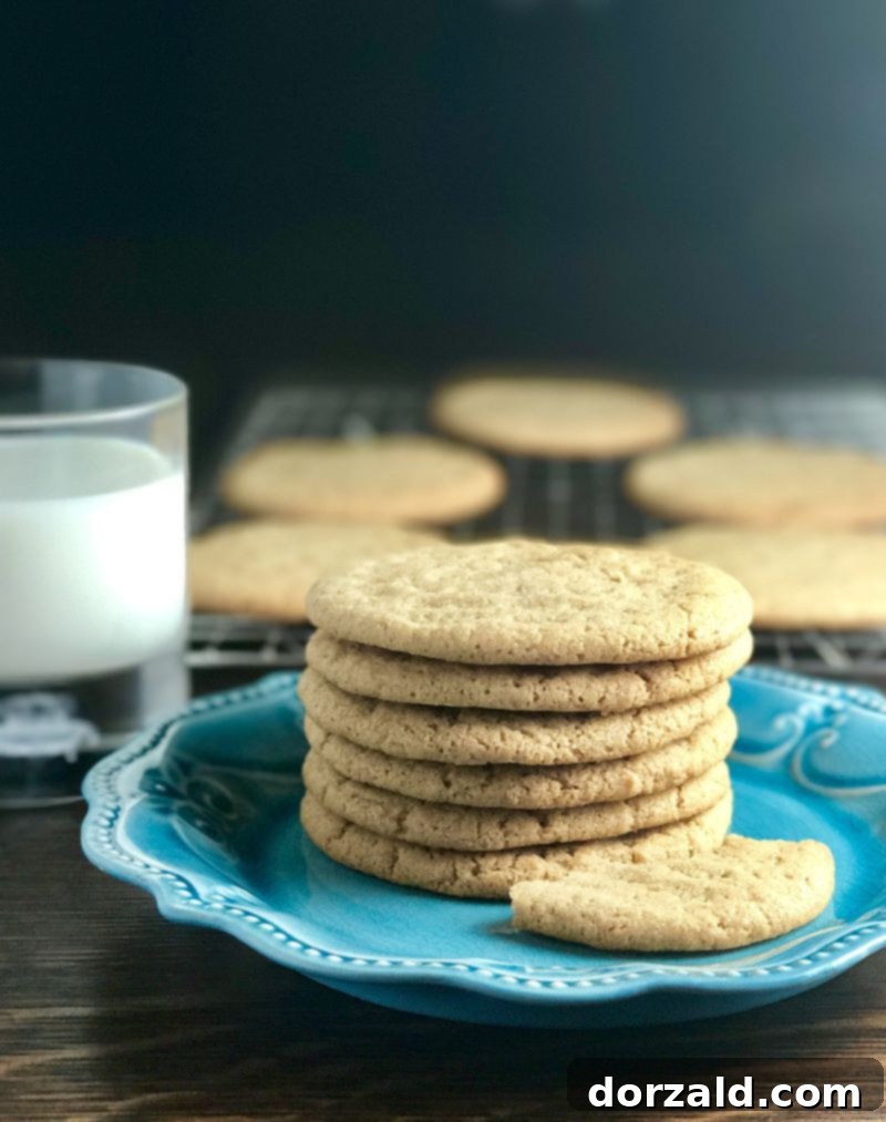 Vegan Almond Butter Delights 2 Dairy-Free Almond Nut Butter Cookies - Golden brown, soft cookies stacked on a plate with a glass of almond milk