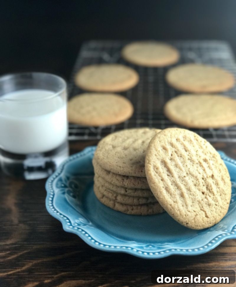 Vegan Almond Butter Cookies 3 Close-up of a plate of Dairy-Free Almond Nut Butter Cookies with a glass of almond milk in the background.