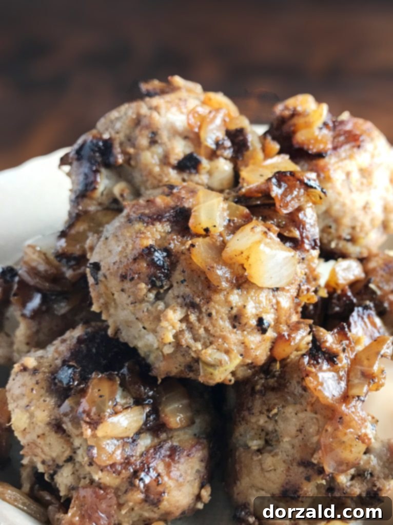 Perfectly browned turkey meatballs cooking in a non-stick skillet