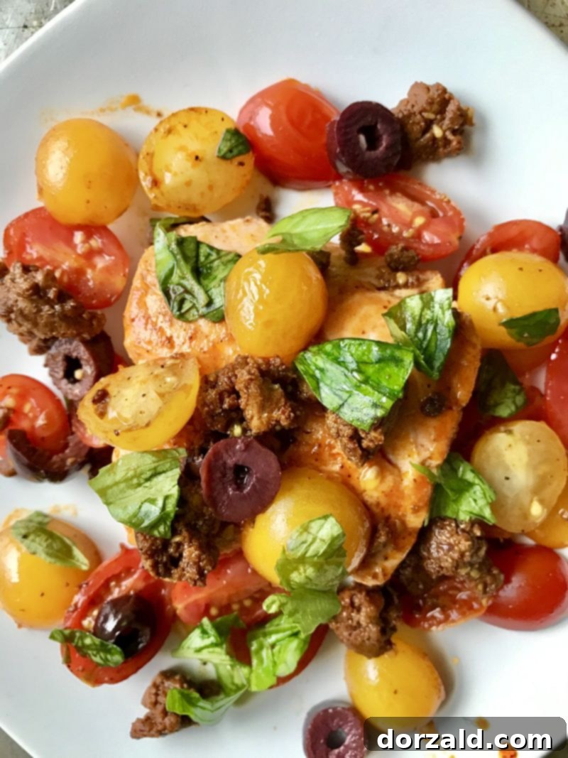 Close-up of a plated Tomato Chorizo Salmon dish showcasing crispy salmon skin and vibrant tomatoes