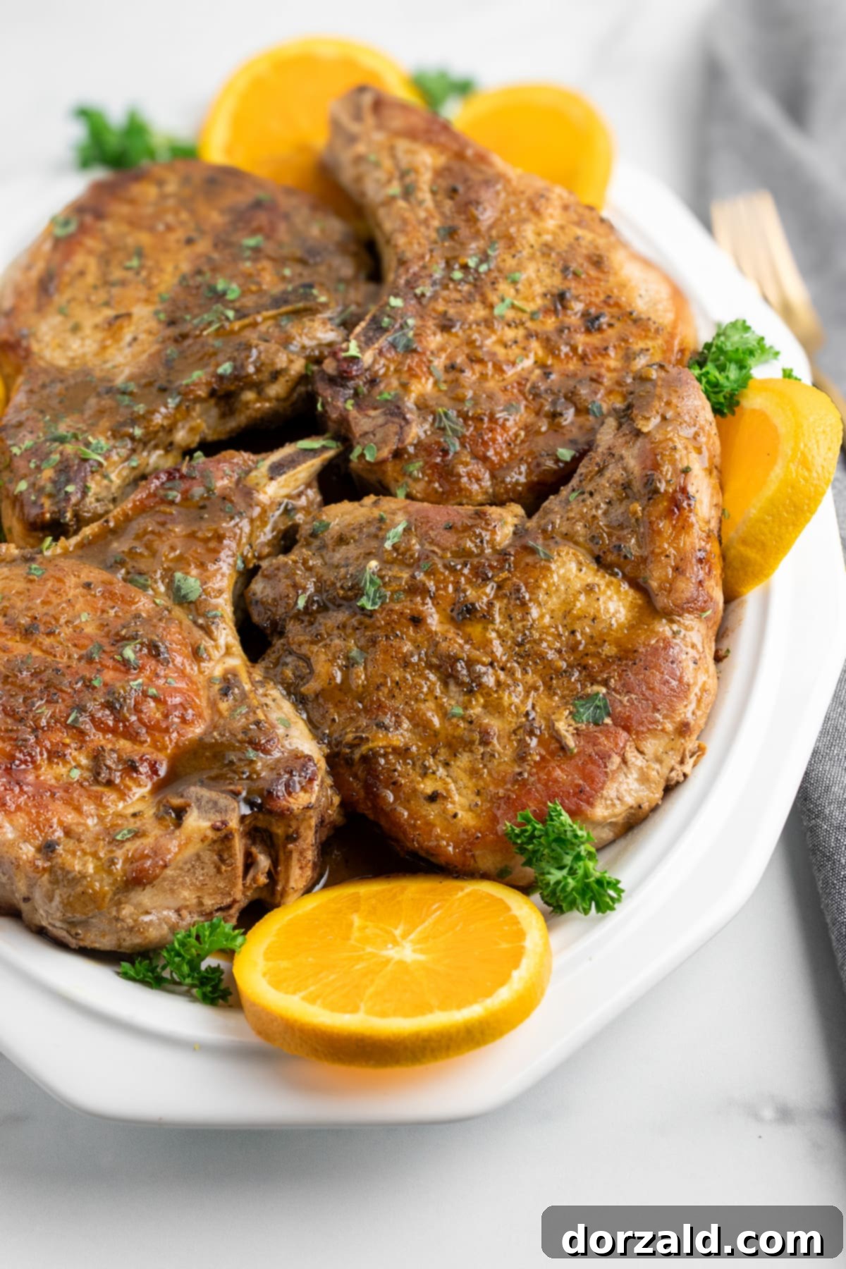 Close-up of a plated Mojo Pork Chop with rich sauce and fresh garnish.