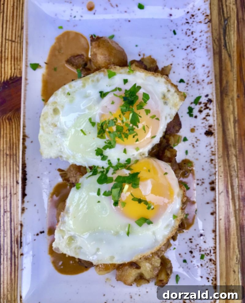 Stock and Barrel Dallas Review 4 Close-up of the Wood Grilled Wagyu Meatloaf with gravy, hash, and a fried egg.