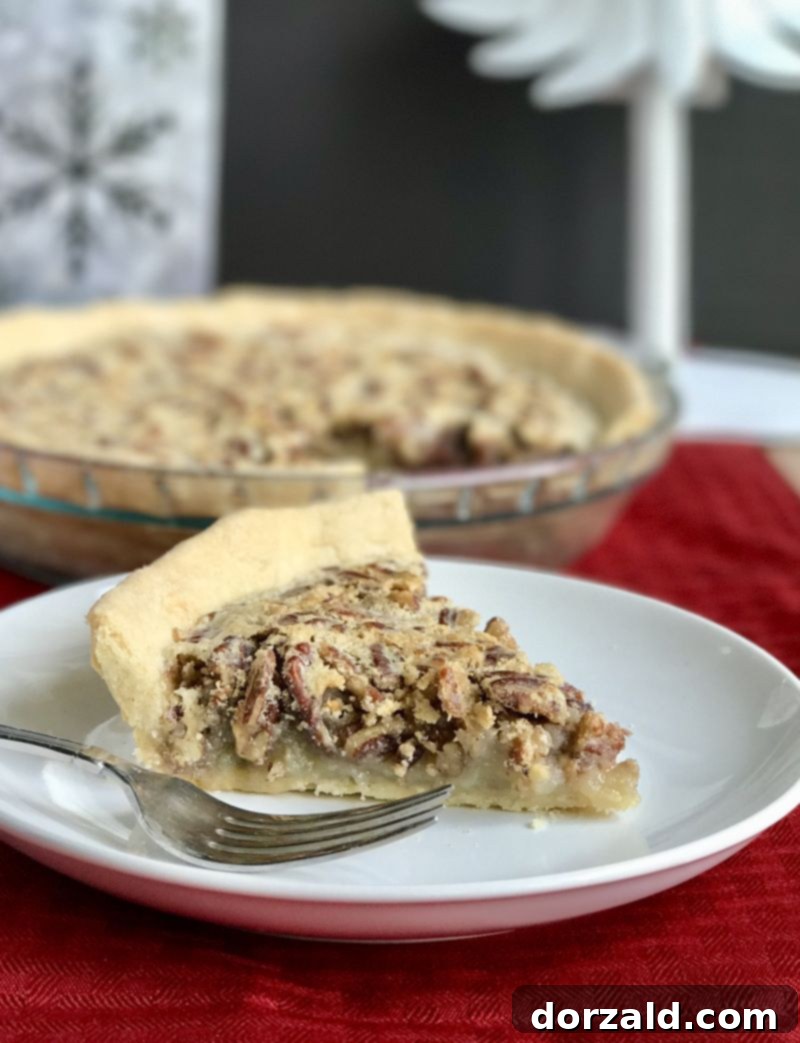 Zesty Dairy-Free Lemon Pecan Pie 4 Slice of Lemon Pecan Pie on a white plate with a fork.
