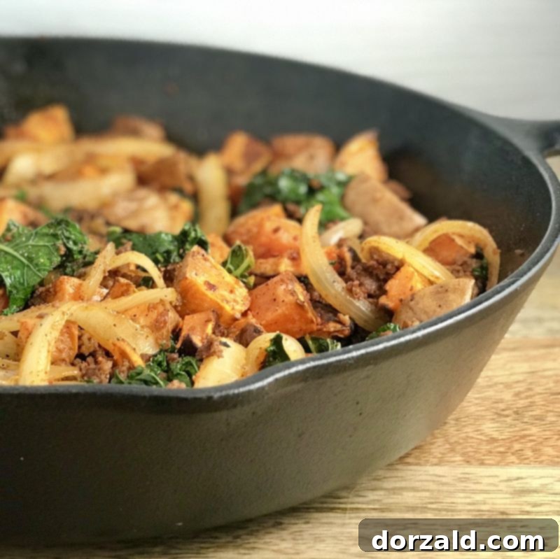 A close-up shot of Chorizo Sweet Potato Kale Hash, highlighting the textures of the ingredients and the inviting steam, perfect for illustrating a comforting make-ahead meal.