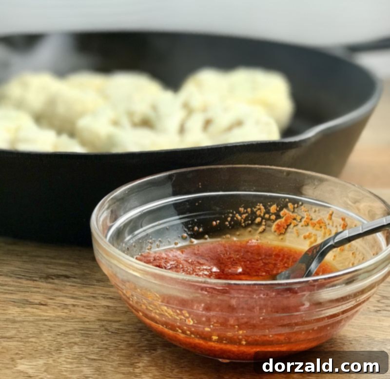 Mixing the Red Thai curry paste with olive oil, salt, and pepper for the cauliflower marinade.