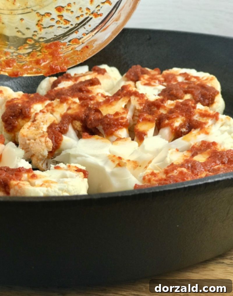 Spreading the homemade Red Thai curry marinade onto the cauliflower steaks before roasting.