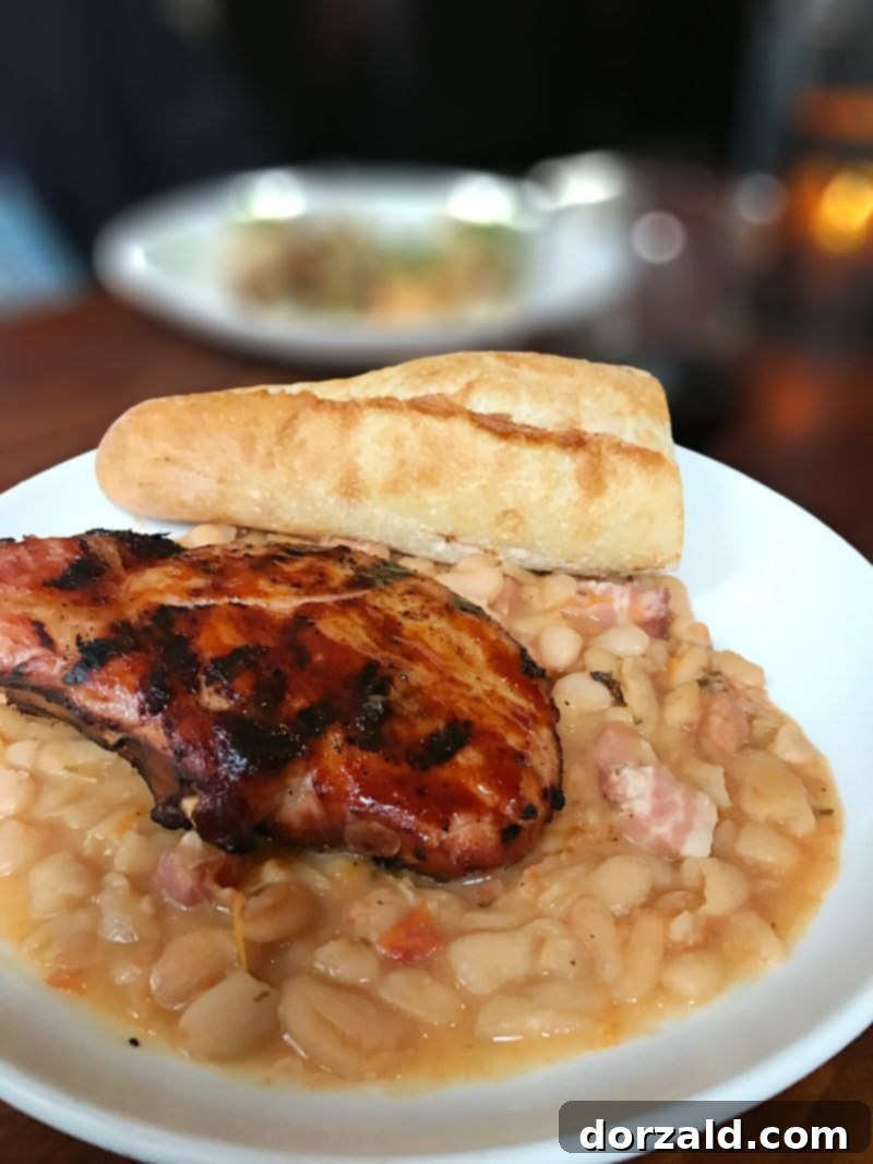 Pork Chop 101, a robust and comforting dish, perfectly cooked and presented at The Woolworth Dallas.