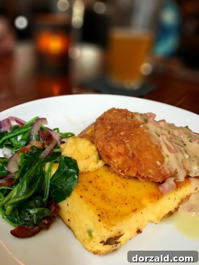 Southern Fried Chicken with red-eye gravy, smoked gouda jalapeno polenta, and braised spinach at The Woolworth Dallas.