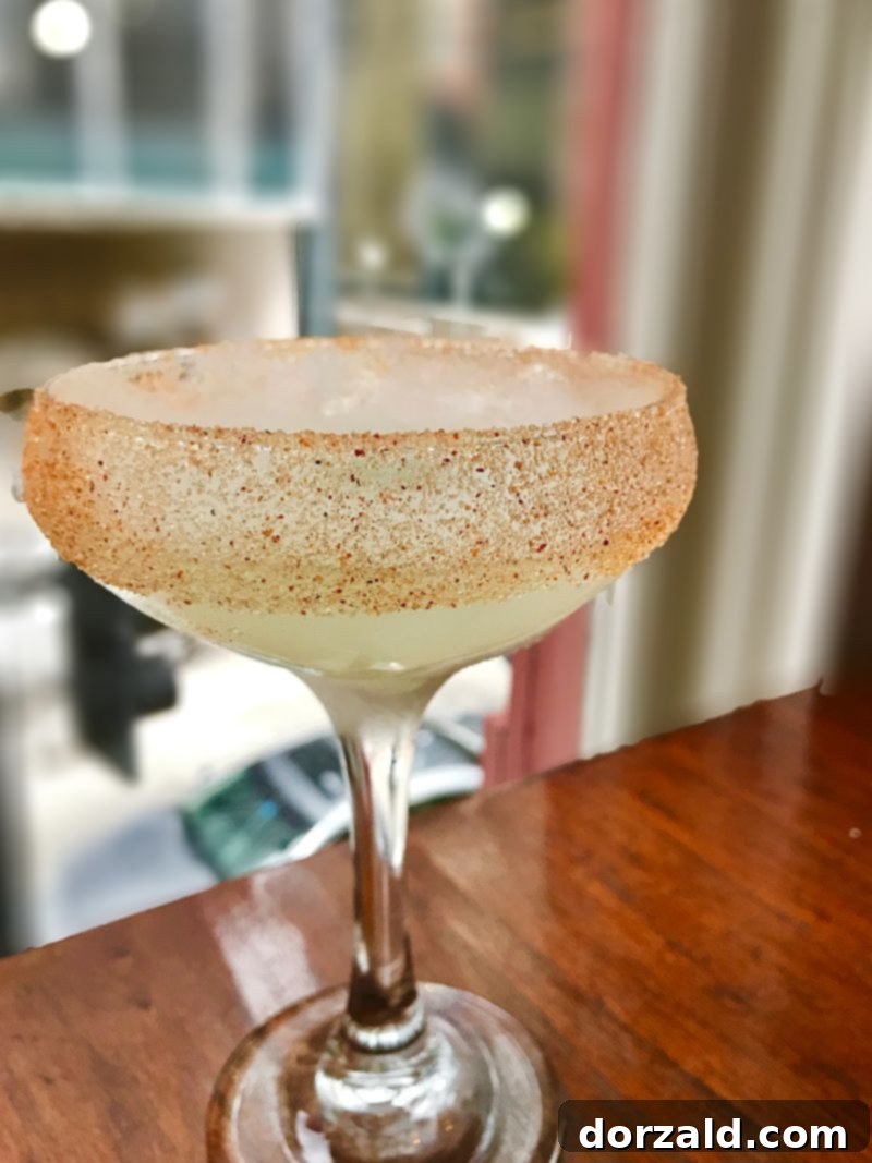 The Smoke and Spice cocktail, a signature drink at The Woolworth Dallas with a dramatic smoky effect, on a bar counter.