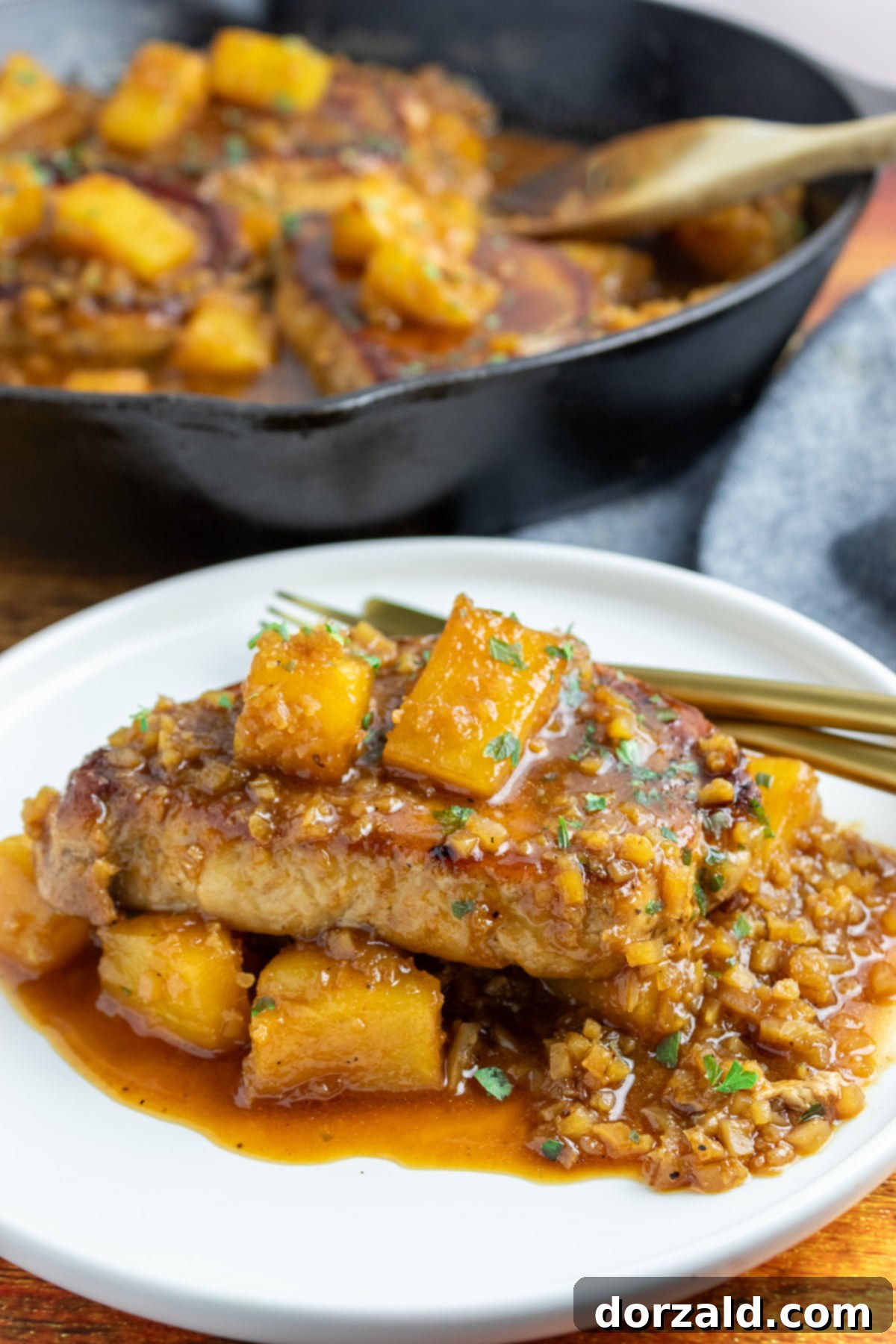 Sweet and savory brown sugar pineapple pork chops in a skillet with riced cauliflower