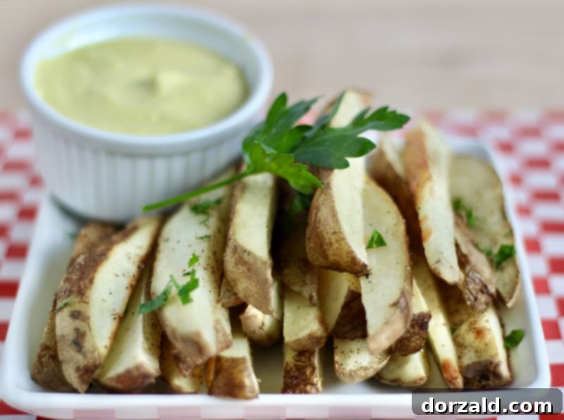 Baked Vegan Cheese Fries with a generous drizzle of dairy-free sauce, showing a close-up of the creamy texture