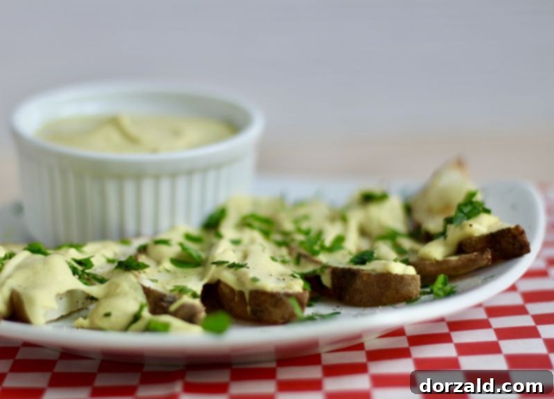 Close-up of creamy Dairy-Free Cheese Fries with fresh green garnish, ready for digging in