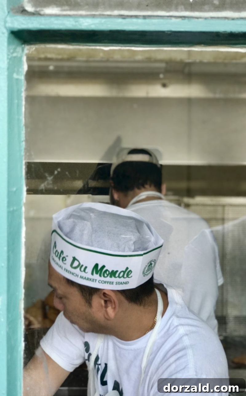 Behind-the-scenes view of beignet dough being prepared and cut at Cafe Du Monde