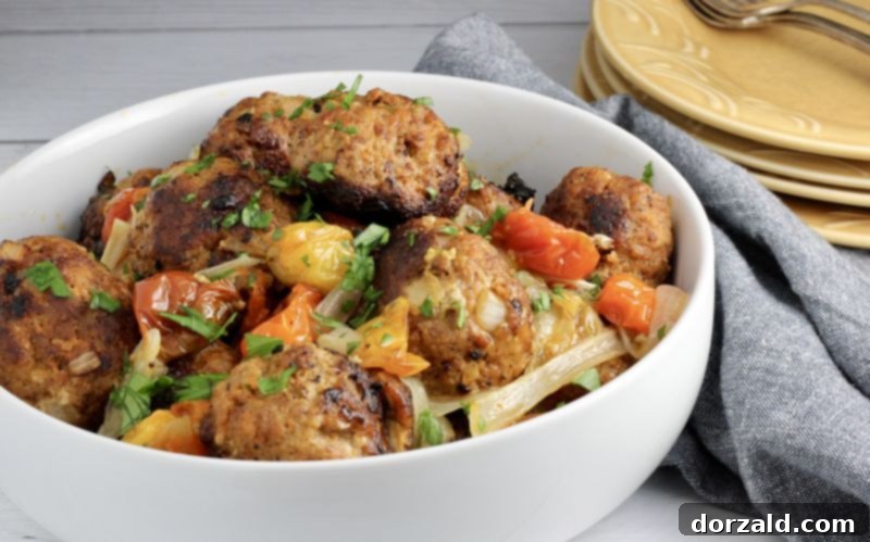 Turkey chorizo meatballs served with a vibrant side of oven roasted cherry tomatoes, garlic, and onions
