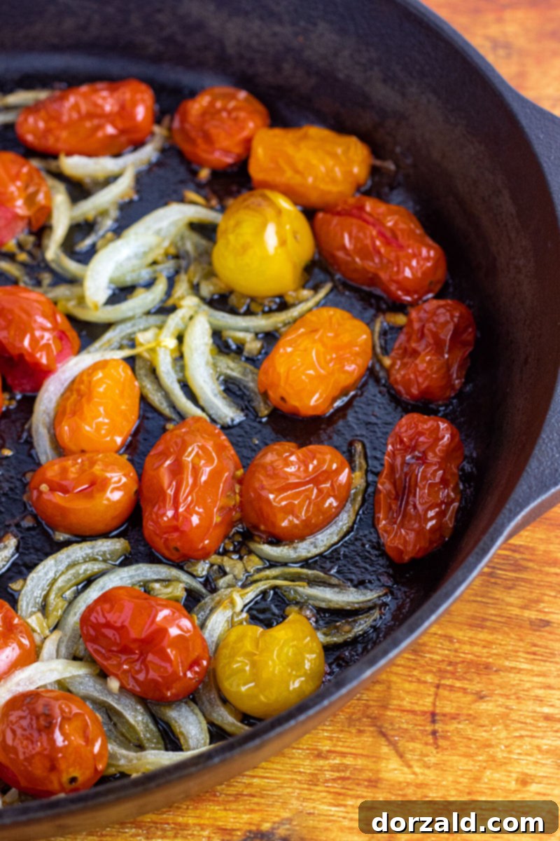 Oven Roasted Cherry Tomatoes with Sliced Onions and Garlic in a Cast Iron Skillet before roasting