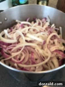 Thinly sliced onions in a pot, ready for caramelization