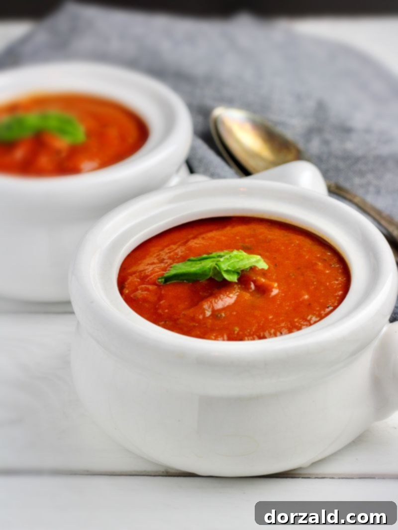 Rich and creamy vegan Whole30 tomato basil soup in a bowl with fresh basil