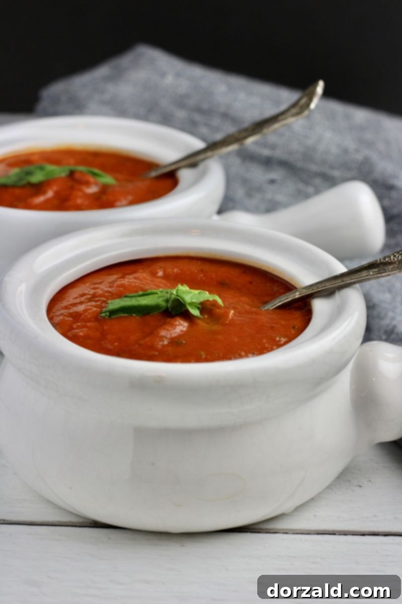 A large pot of vegan Whole30 tomato basil soup simmering on the stove, ready for blending