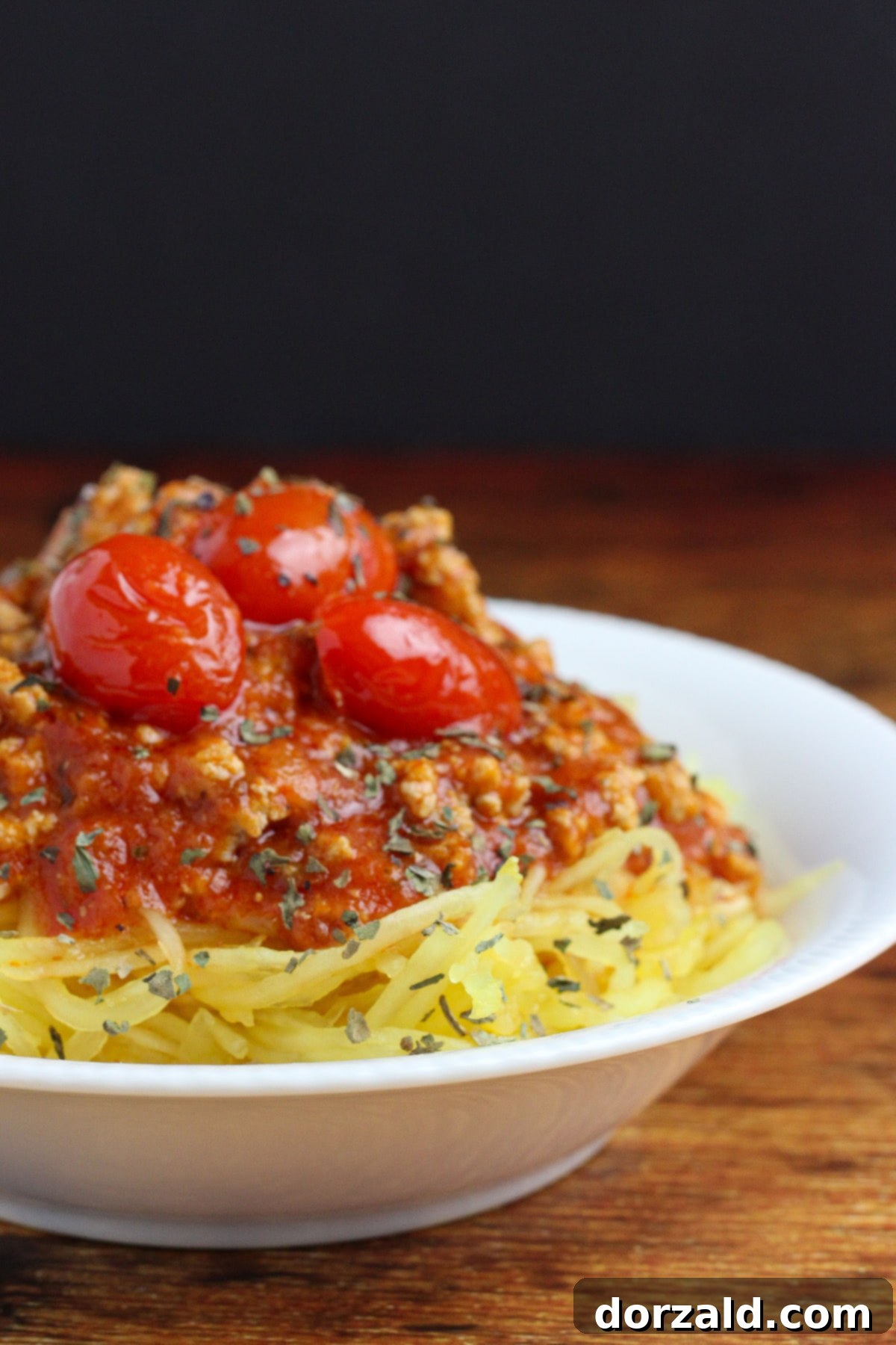 Paleo Low Carb Whole30 Spaghetti Squash 2 paleo spaghetti squash - in a white bowl, ready to eat and topped with meat sauce and cherry tomatoes