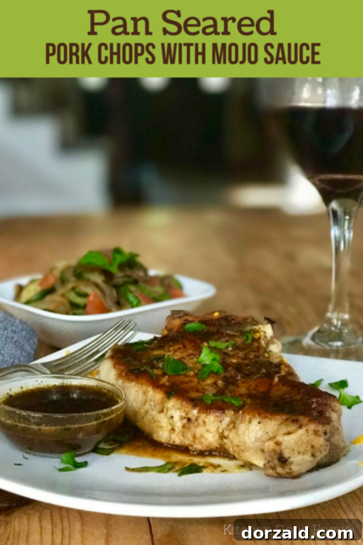 Perfectly Pan Seared Pork Chops generously topped with a vibrant Mojo Sauce and fresh herbs