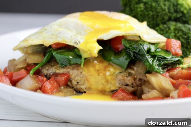 Veggie-infused turkey burger with a fried egg on top and sauteed vegetables