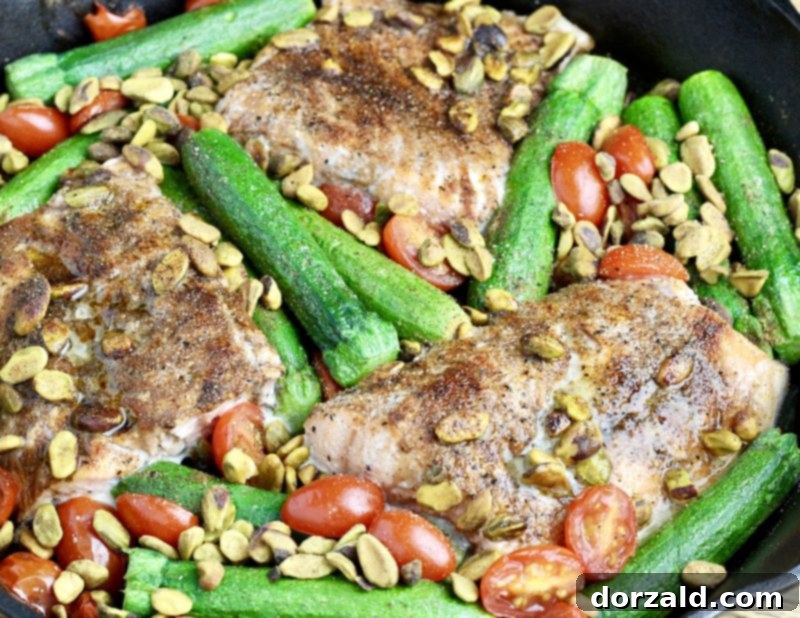 one pan pistachio salmon and roasted vegetables in a cast iron pan, ready to serve