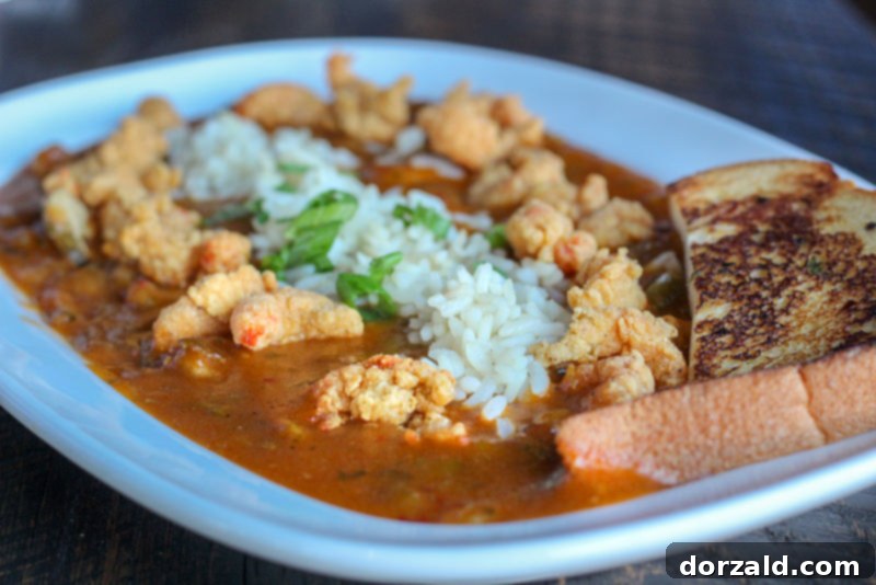 Walk-On's Bistreaux & Bar Arlington Review 9 Crawfish Etou-Ways, crawfish étouffée with fried crawfish, rice, and garlic bread at Walk-On's Arlington Texas