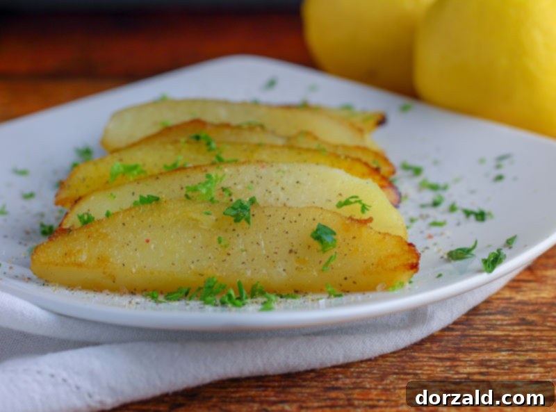 close up of roasted lemon potatoes wedges in a cast iron skillet