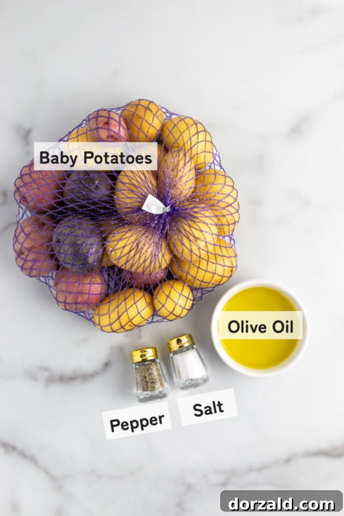 Fresh baby potatoes, olive oil, salt, and pepper laid out as ingredients for a simple recipe.