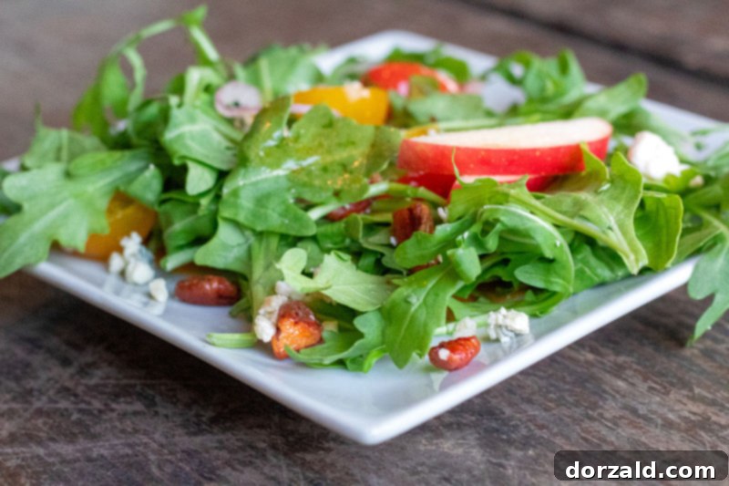 Fresh Baby Arugula Salad, garnished with various toppings, presented at Checkered Past Winery in Dallas.