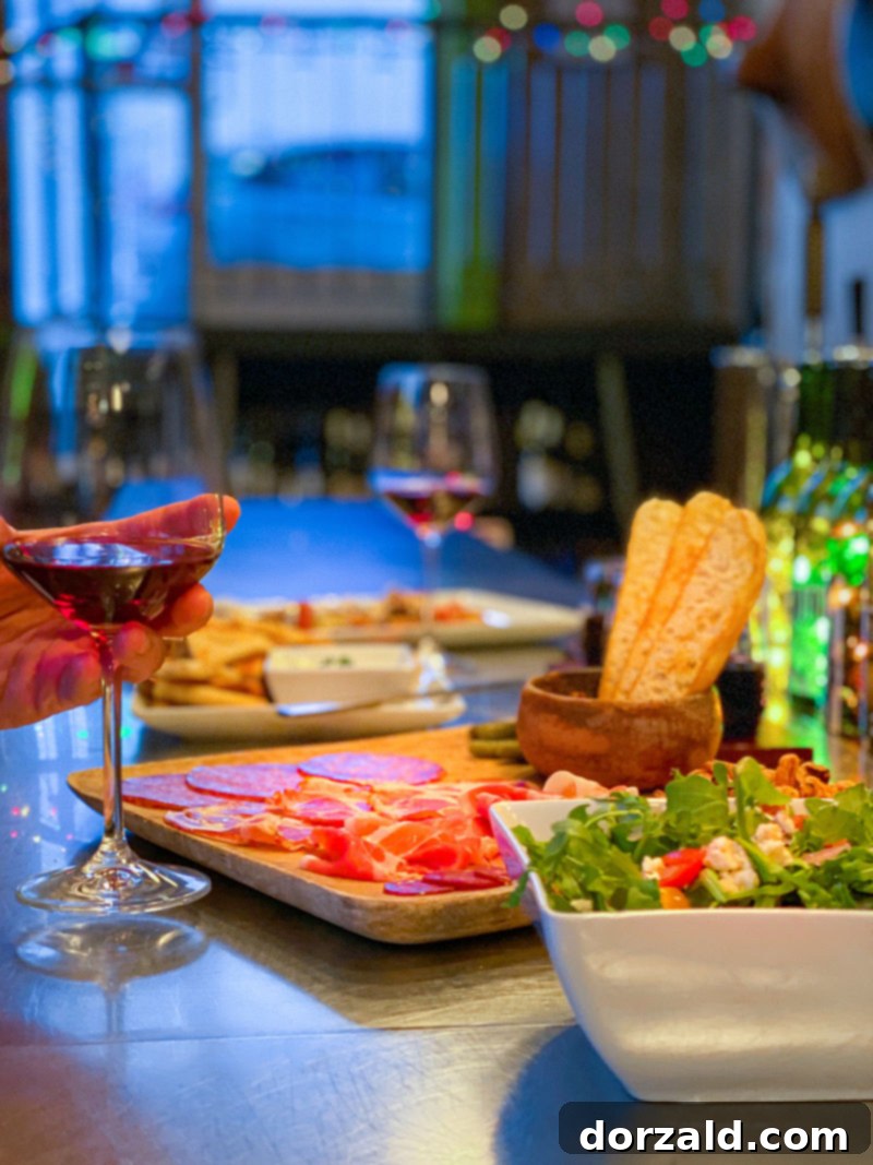 An inviting scene with wine glasses, bottles, and food laid out on a table, bathed in the soft evening light at Checkered Past Winery.