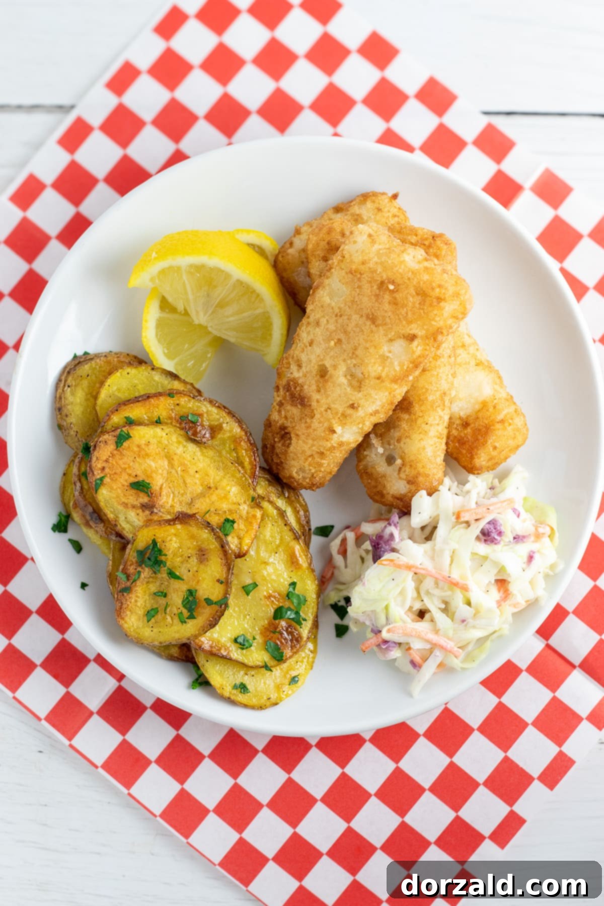 A serving of freshly baked malt vinegar potato chips on a white plate, ready to be enjoyed.