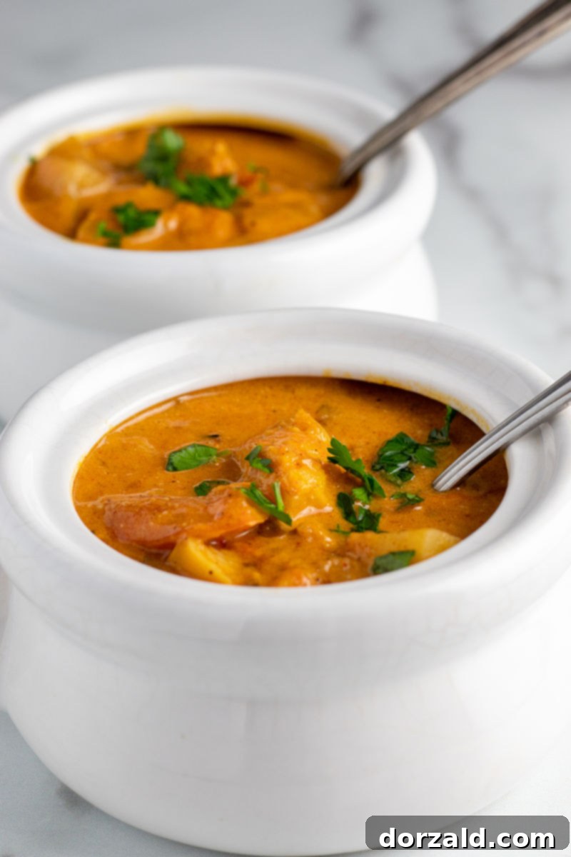 Four white bowls filled with Brazilian Fish Stew (Moqueca), ready to be served
