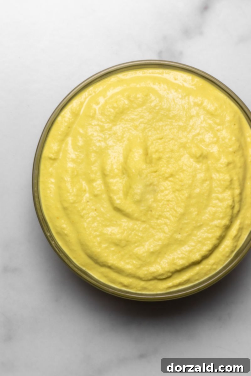 Creamy dairy-free cashew cheese sauce in a bowl, perfect for dipping or pouring