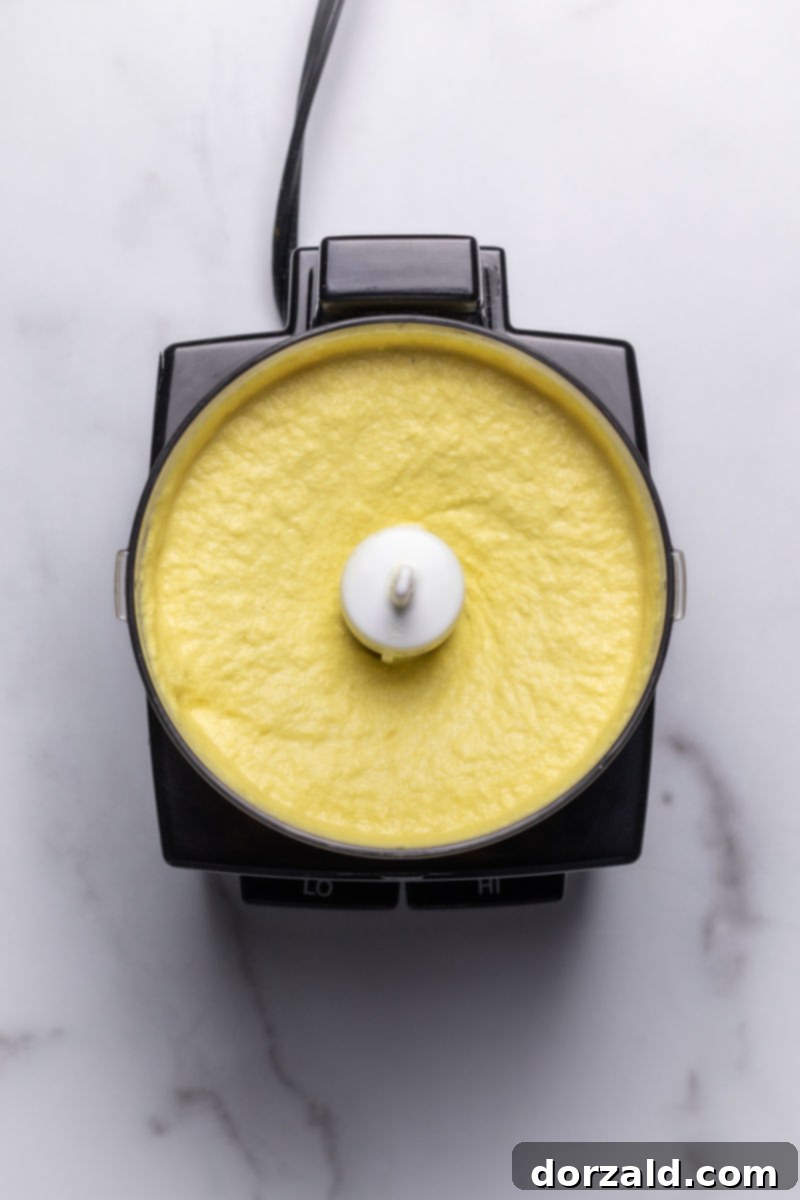 Seasoning the dairy-free cashew cheese sauce to taste with salt and pepper