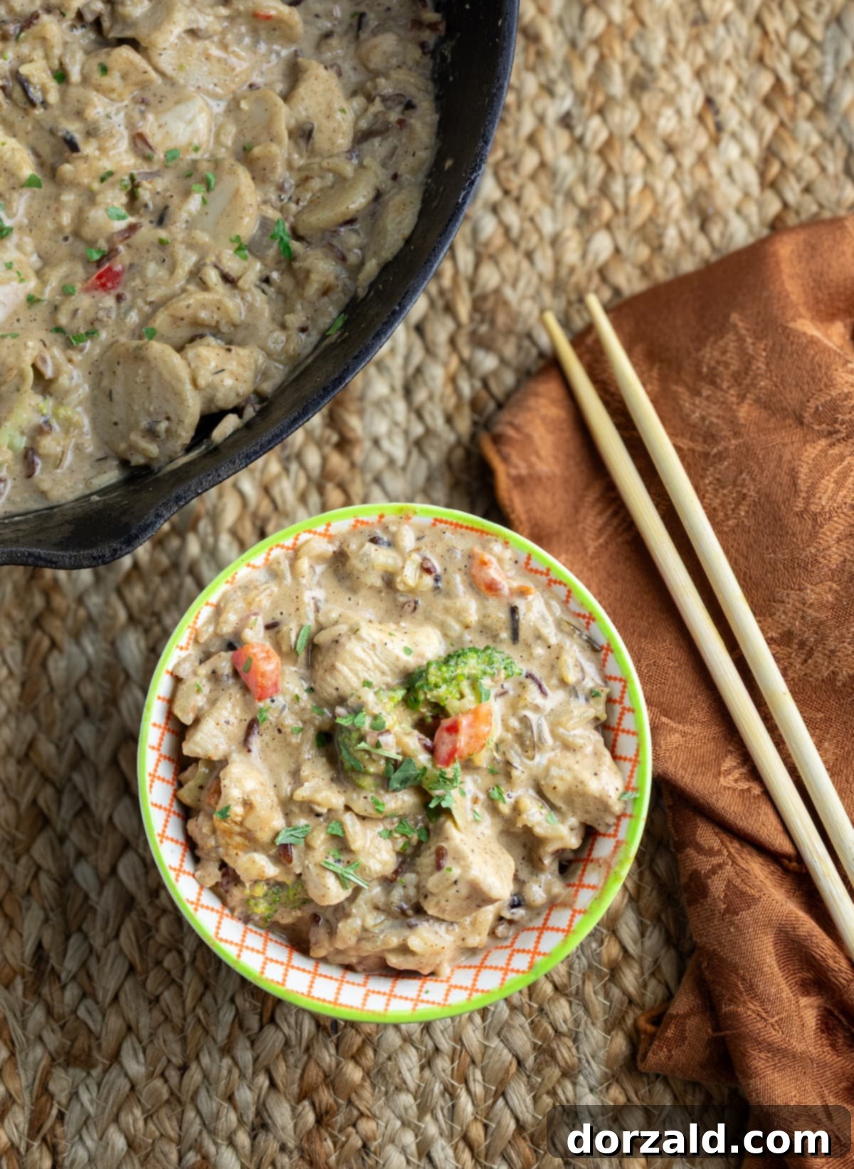 Creamy Almond Butter Coconut Curry Chicken 2 A vibrant bowl of Almond Butter Coconut Curry Chicken with wild rice and fresh parsley garnish.