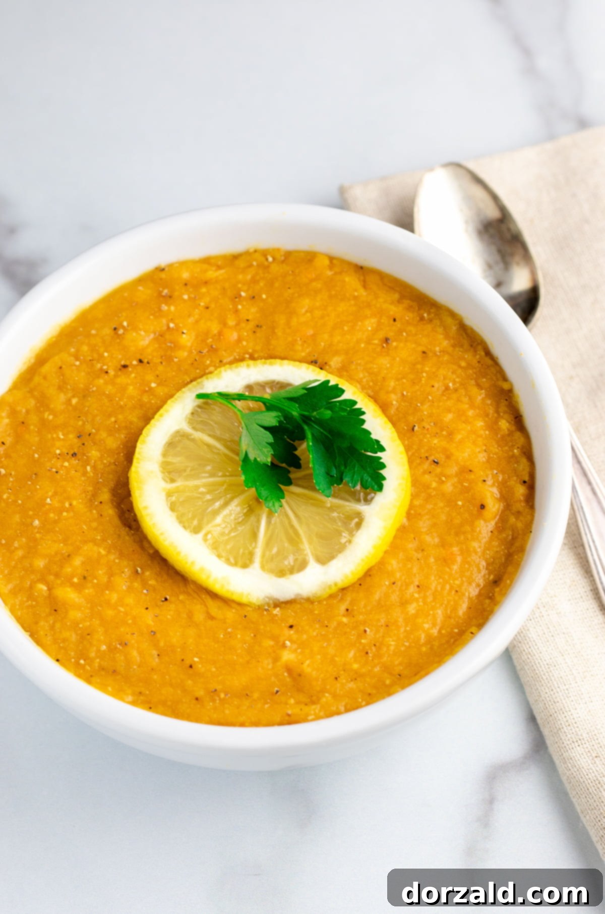 Close-up of uncooked red lentils with a lemon and spices, ready for cooking.