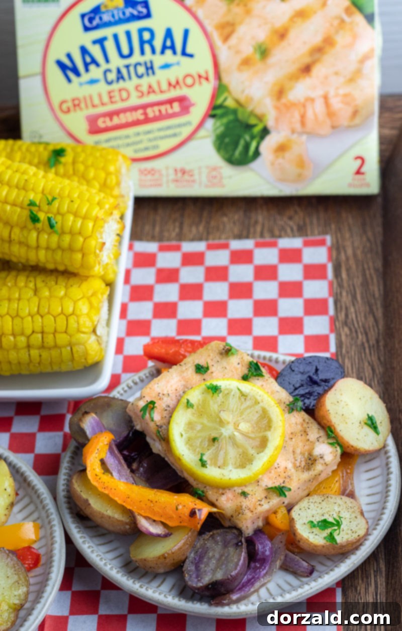 Easy One-Pan Roasted Salmon and Veggies 4 Plate of roasted salmon and vegetables with corn on the cob and a red checkered napkin