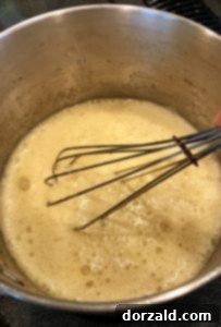 Zesty Vegan Lemon Curd 10 Ingredients for dairy-free lemon curd being whisked in a saucepan.