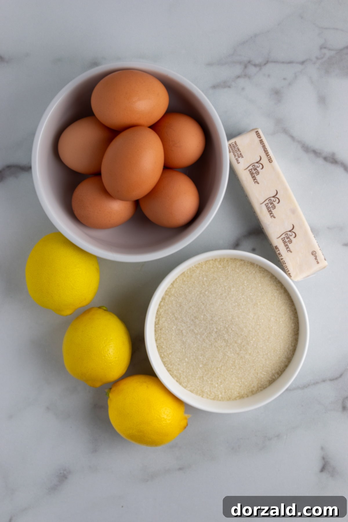 Ingredients for lemon curd including fresh lemons and egg yolks