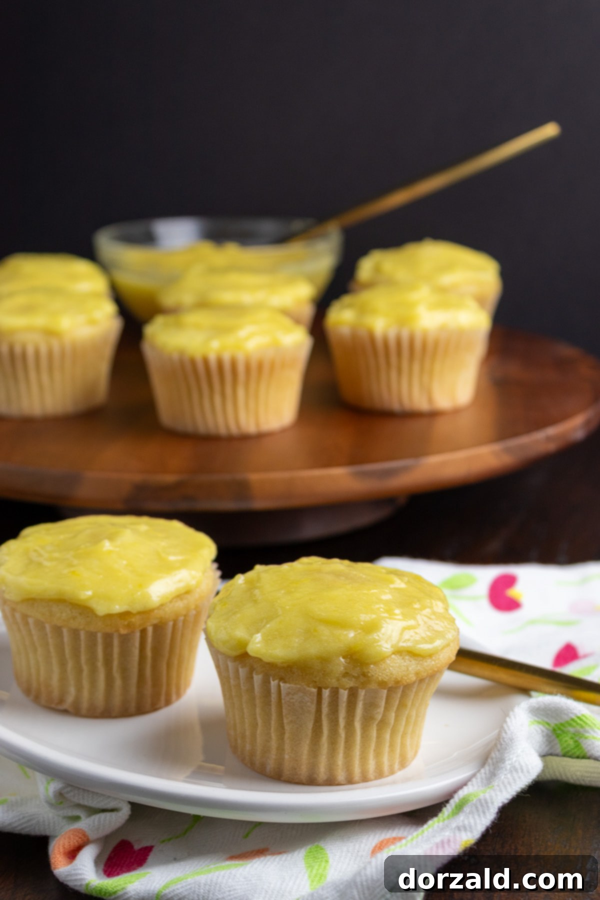 Finished lemon curd filled lemon cupcakes with a spoon of curd on top
