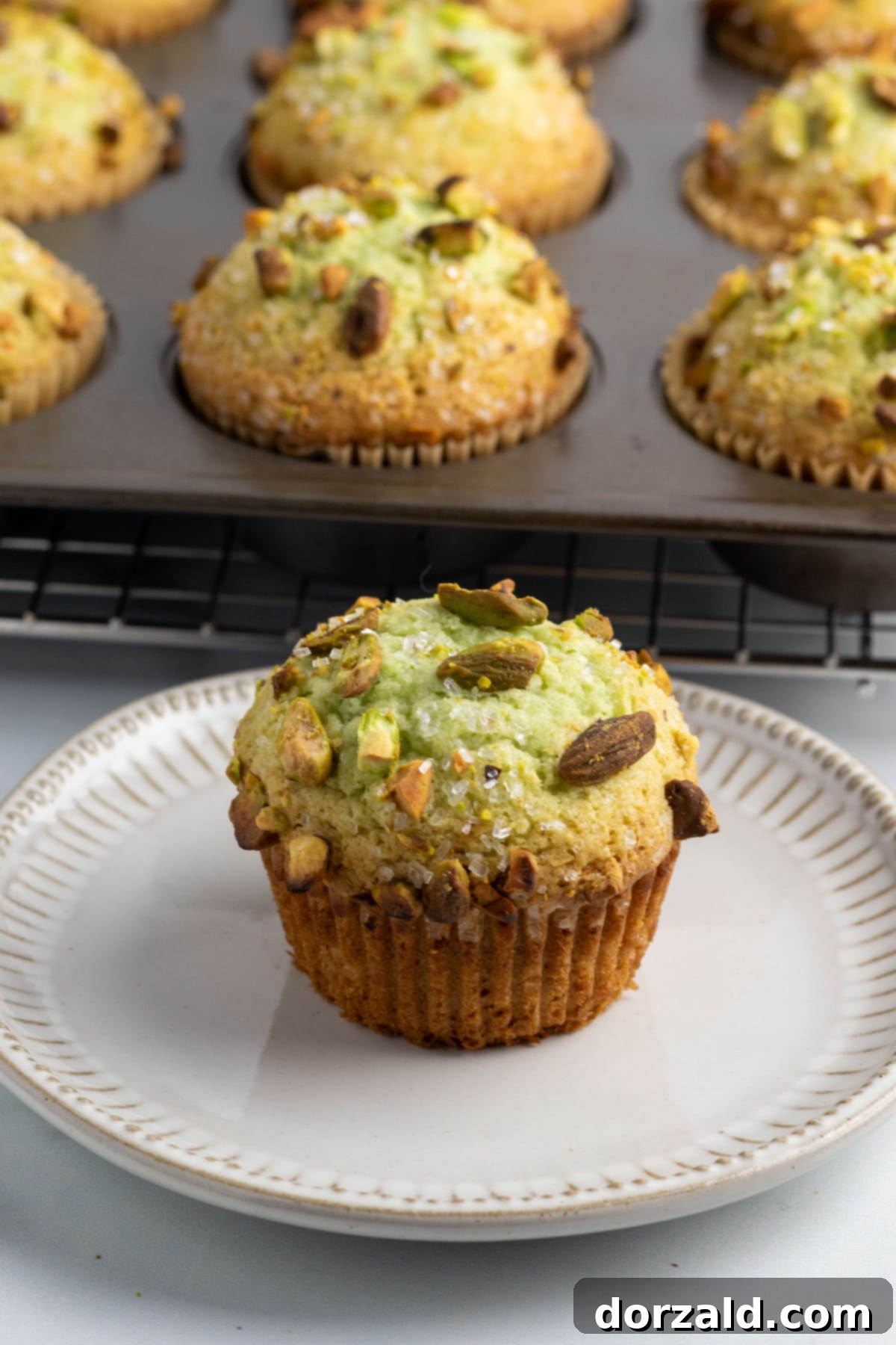 Beautifully arranged dairy-free pistachio muffins on a cooling rack