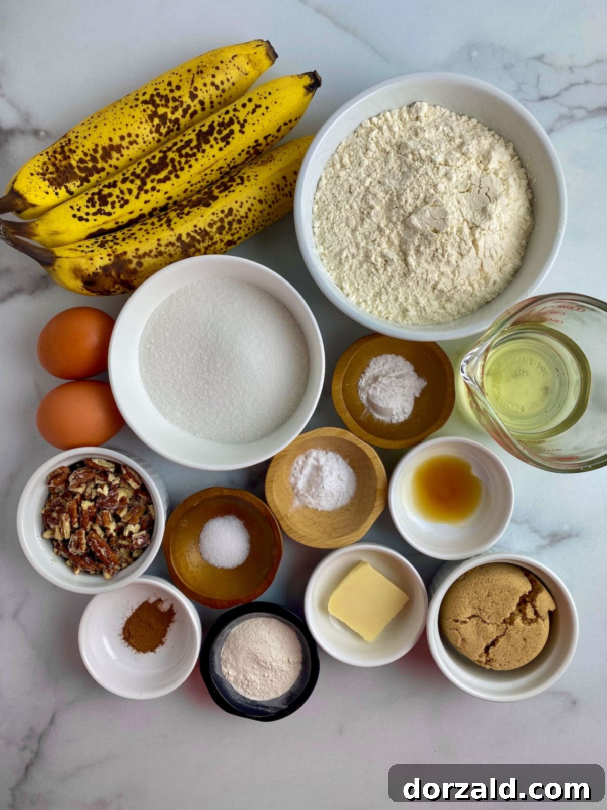 Ingredients for dairy-free banana muffins laid out on a kitchen counter, including ripe bananas, flour, oil, and eggs.