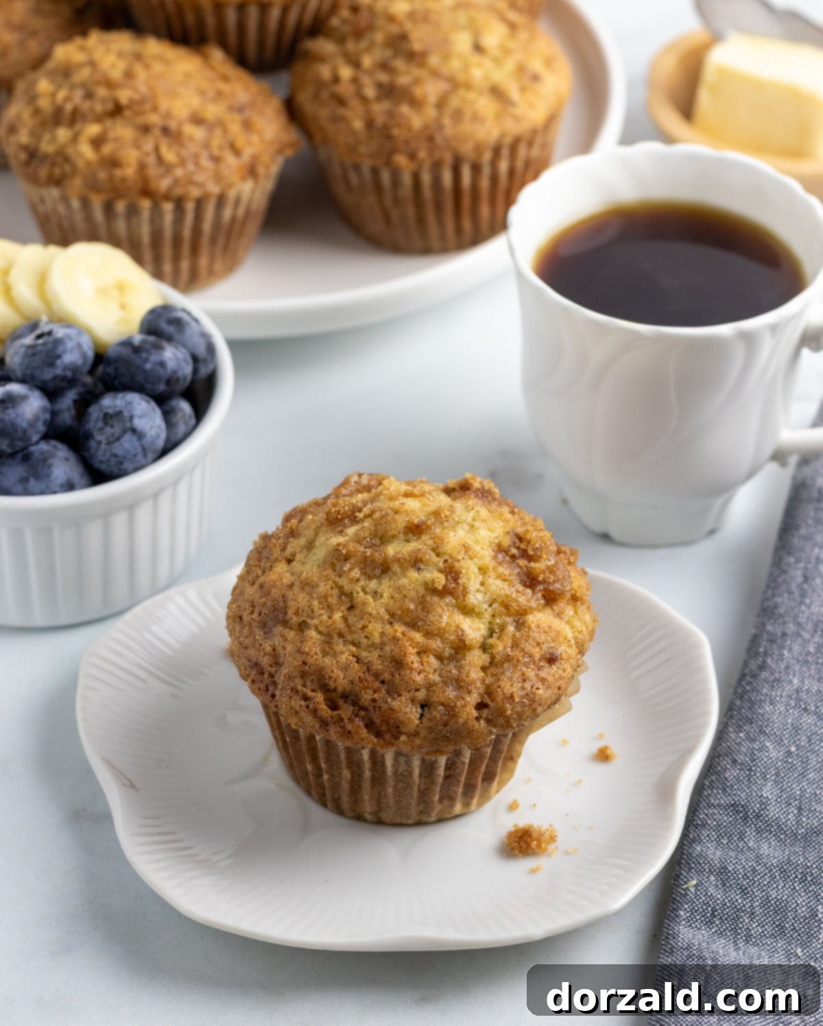 Freshly baked dairy-free banana muffins with a golden brown sugar crunch topping, cooling on a wire rack.
