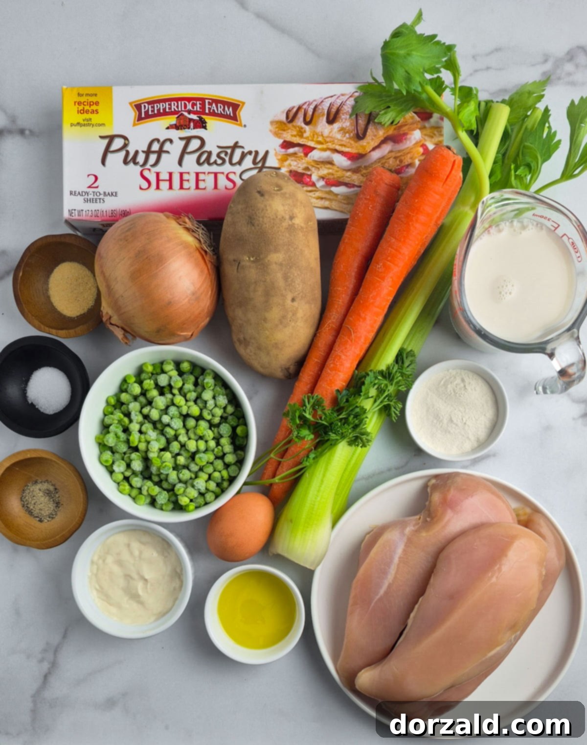 A close-up of the delicious dairy-free chicken pot pie filling, generously portioned into a casserole dish, ready for its flaky pastry topping. The rich, creamy mixture is studded with vibrant vegetables and tender chicken pieces.