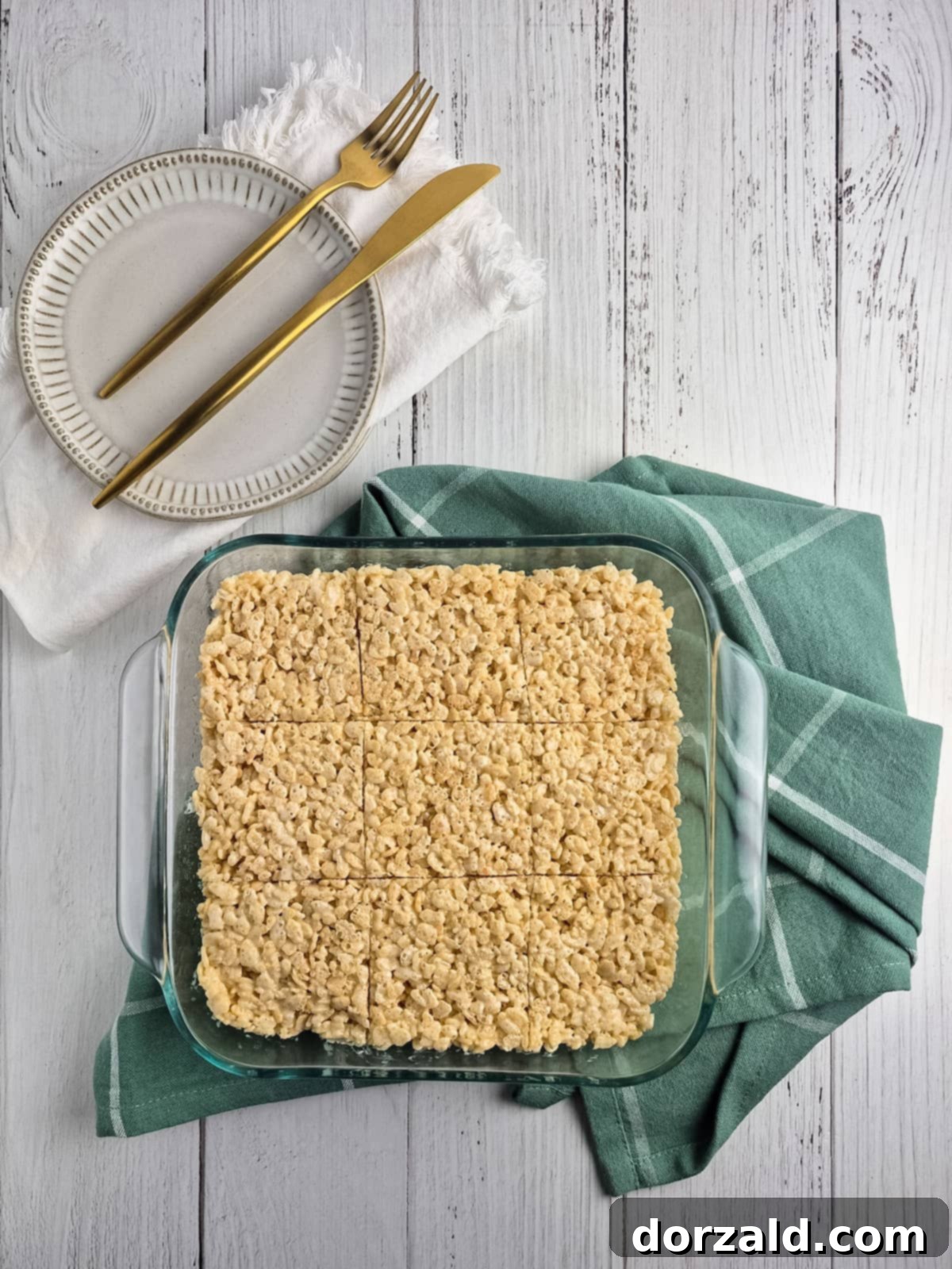 A close-up of the melted dairy-free butter and marshmallows being stirred in a large pot, creating a smooth, gooey base for the treats.