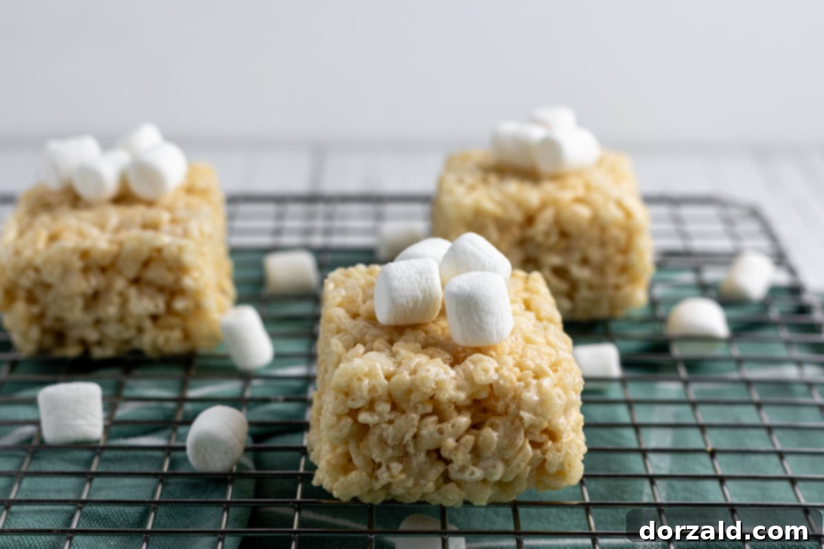 Gooey Dairy-Free Crispy Bites 7 A single Dairy-Free Rice Krispie Treat on a wooden board